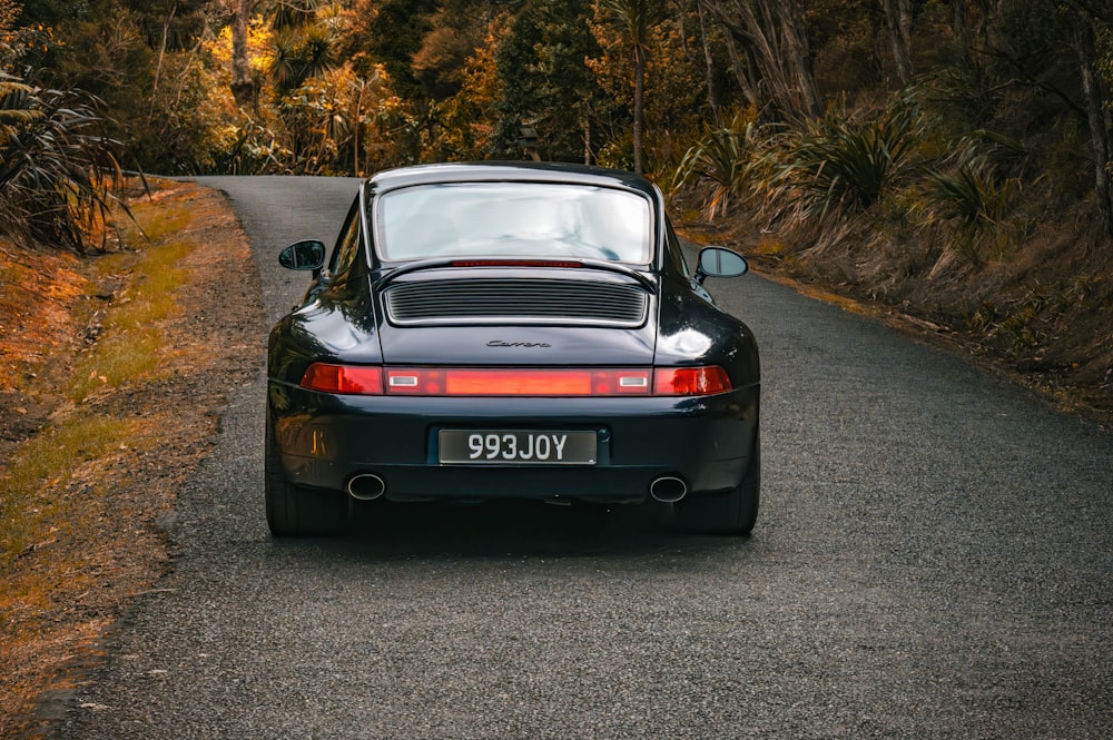 a black porsche parked on the side of a road