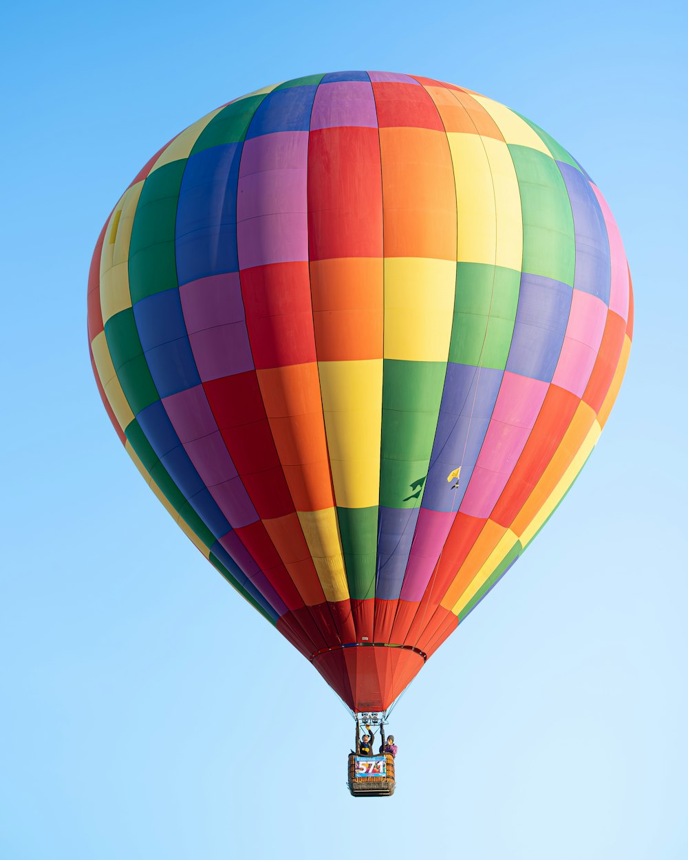 a colorful hot air balloon flying in a blue sky