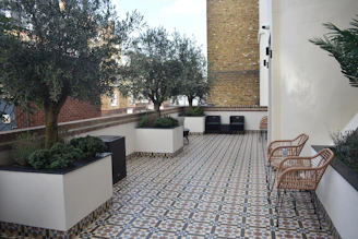 A well-kept terrace with potted plants and a clean balcony area.