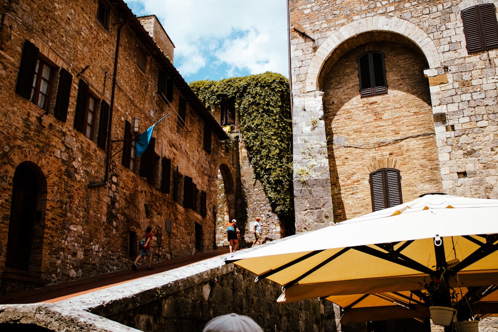 a yellow umbrella sitting next to a brick building