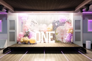 Sparkling backdrop with illuminated custom signs and colorful balloon clusters