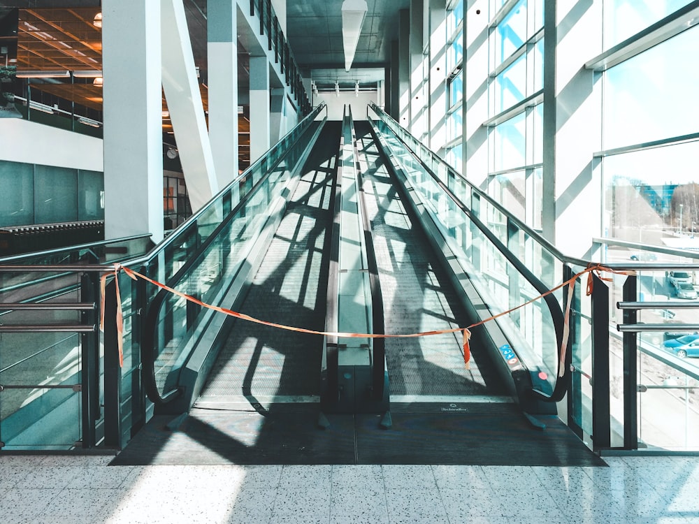 an escalator in a building with glass walls