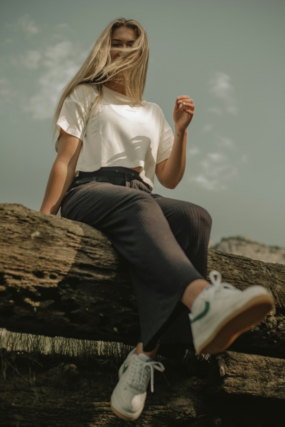 a woman sitting on top of a tree log