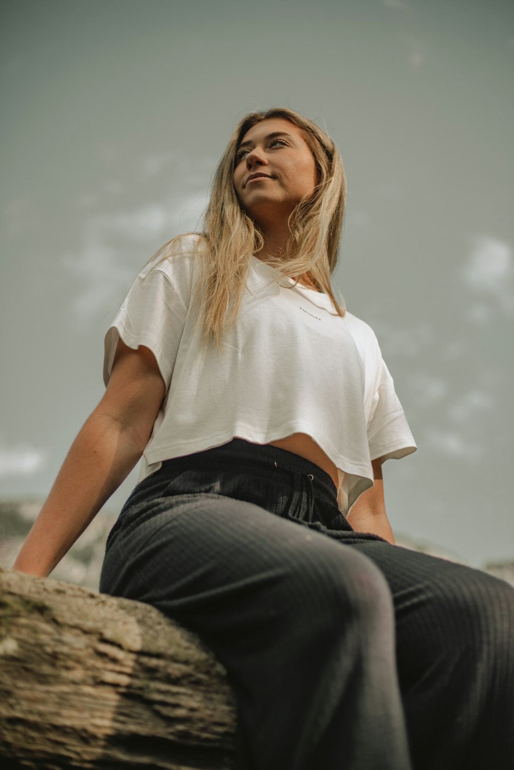 a woman sitting on top of a tree trunk