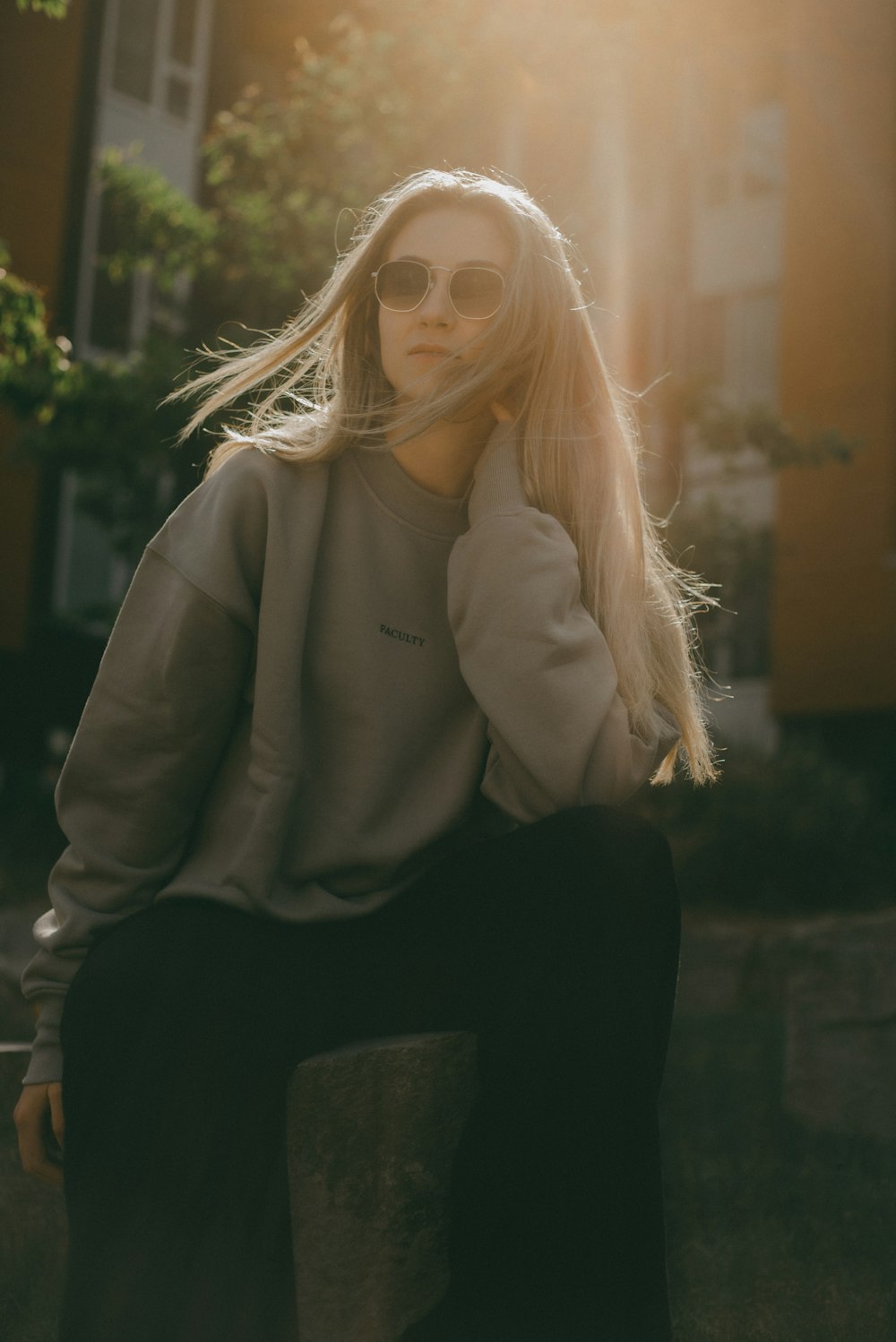 a woman sitting on top of a cement block