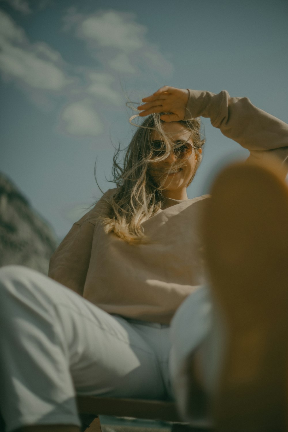 a woman sitting in a chair with her hair blowing in the wind