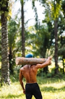 a man carrying a log on his back