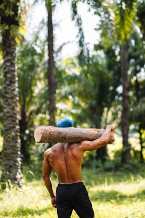 a man carrying a log on his back