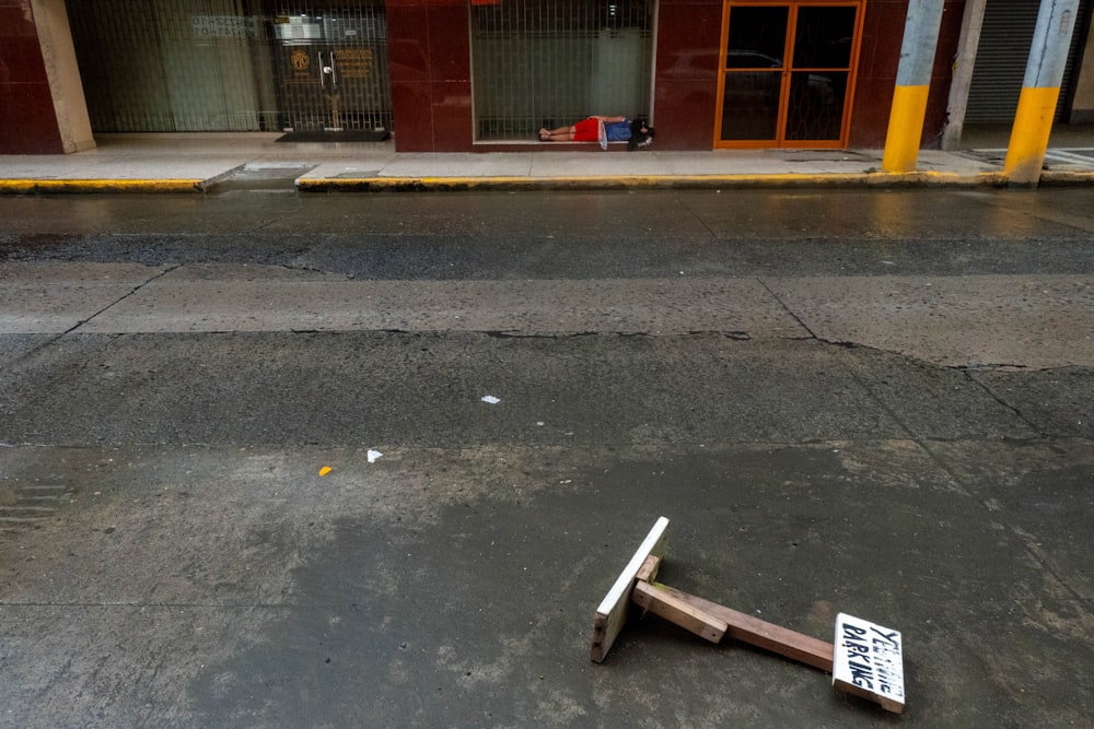 a broken mallet lying on the ground in front of a building