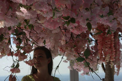 A quiet moment with Millie sitting beneath a blooming sakura tree, the petals gently drifting down.