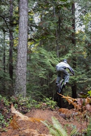 a man riding a bike through a forest