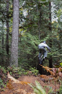 a man riding a bike through a forest