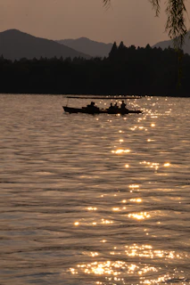 Sunset over a serene mountain lake with a small boat floating gently