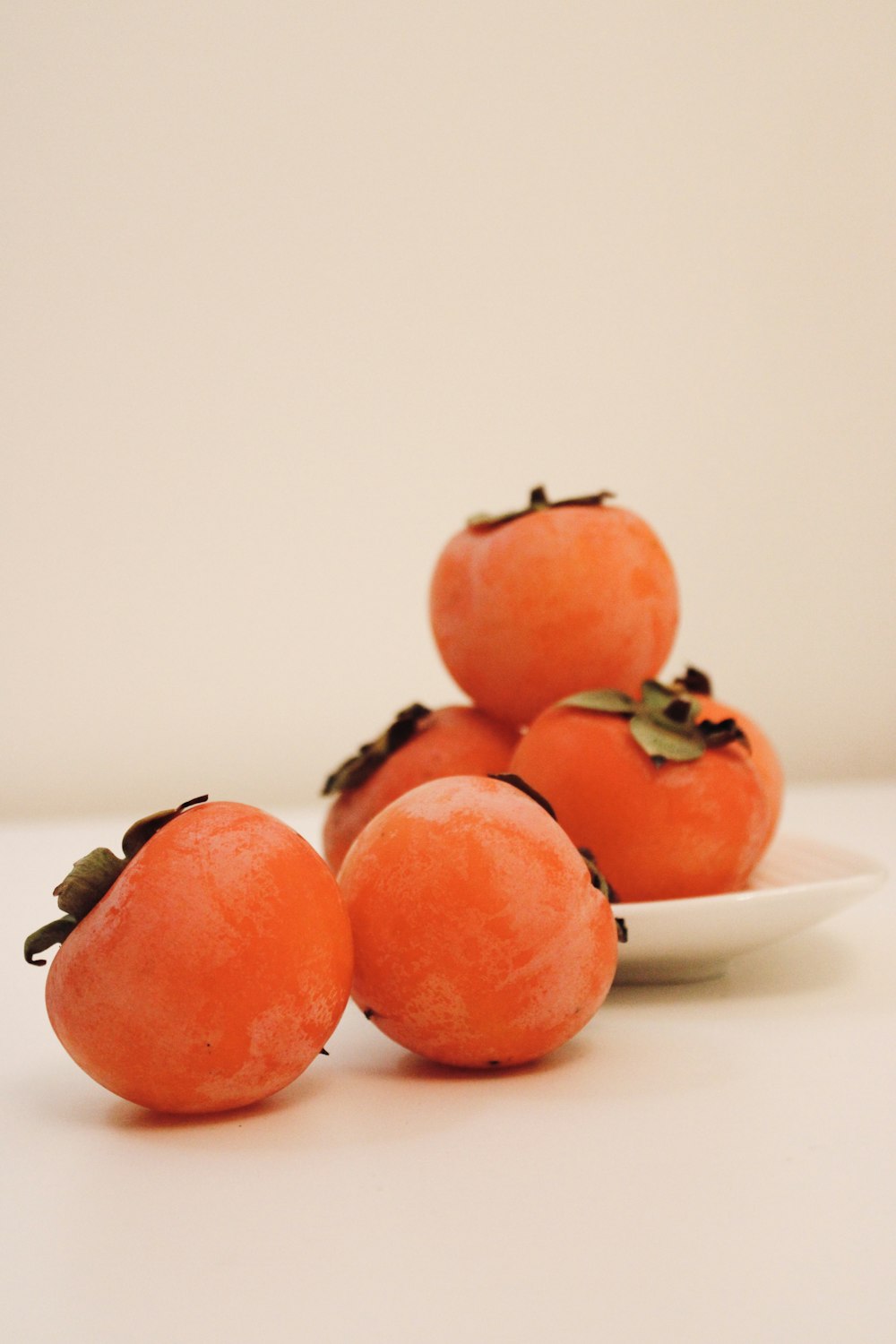 a white plate topped with four oranges on top of a table