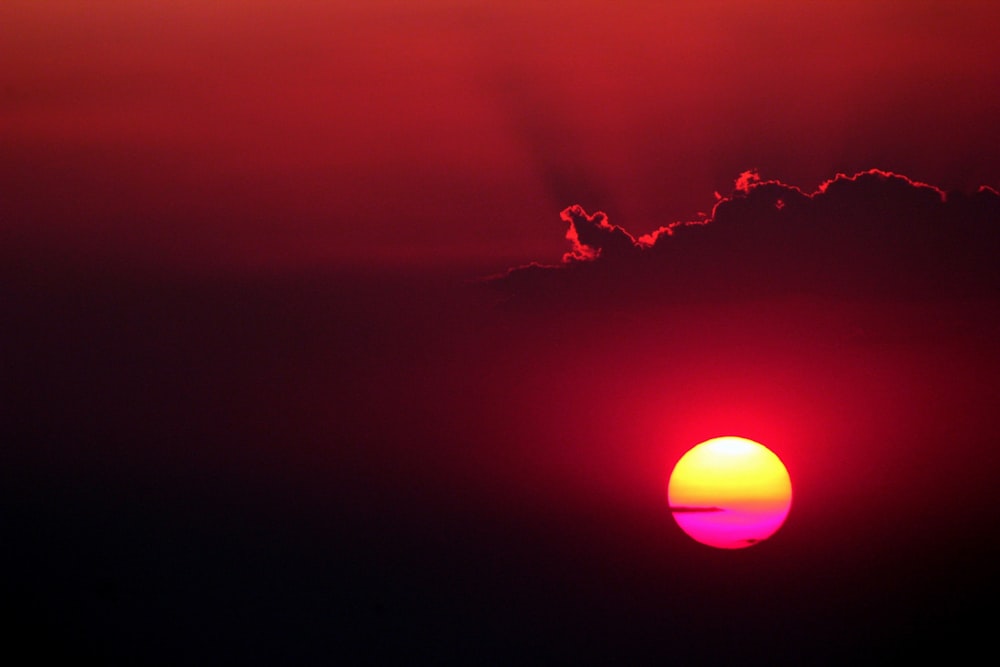 un tramonto rosso e giallo con le nuvole sullo sfondo