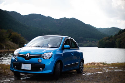 A sleek Renault car parked by a scenic countryside road at sunset.