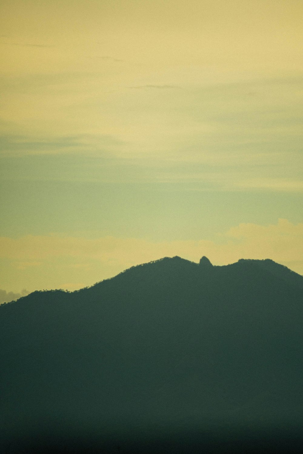 a plane flying over a mountain with a sky background