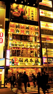 Street scene in Tokyo lit by neon signs, capturing vibrant city nightlife energy.