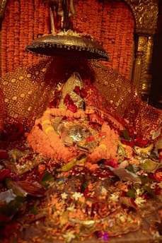 A devotee offering flowers at a traditional Indian temple altar.