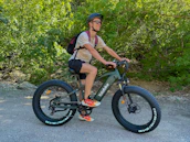 Happy rider testing a Veloforge custom e-bike part on a scenic trail.