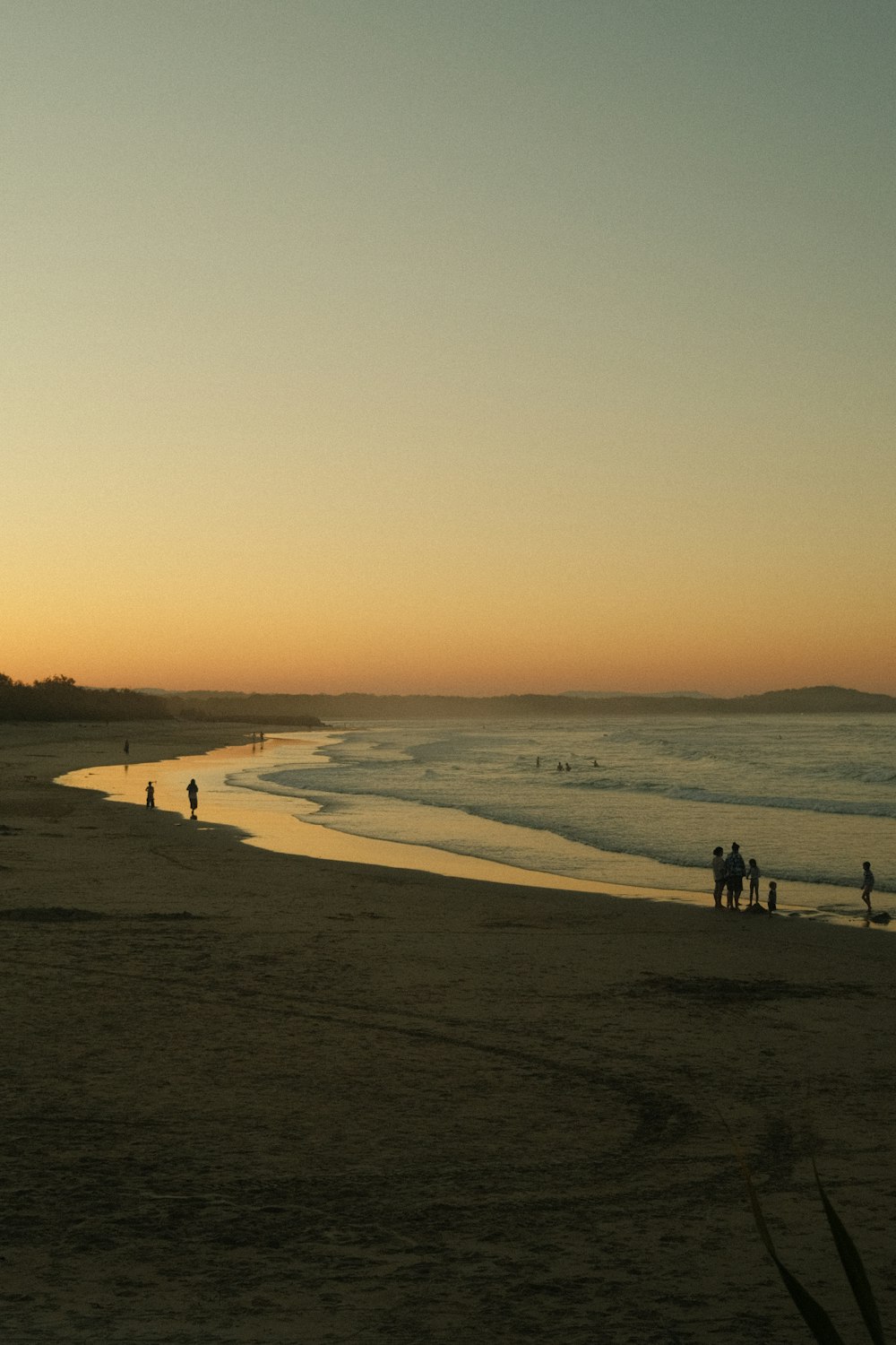 a group of people standing on top of a sandy beach