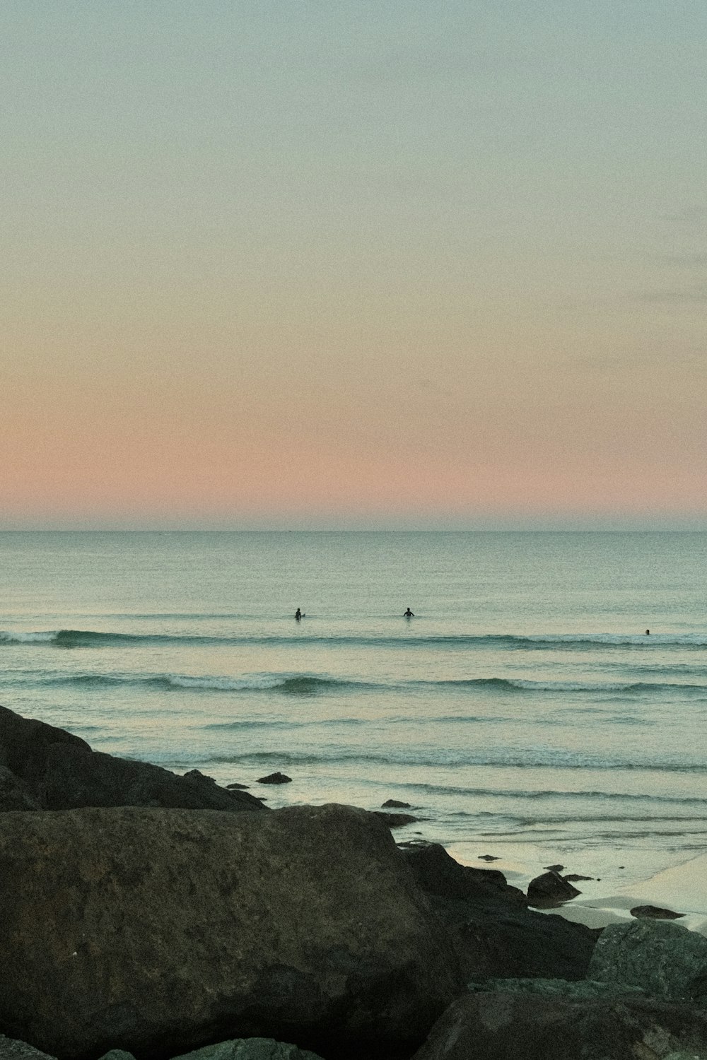 a person standing on a beach holding a surfboard