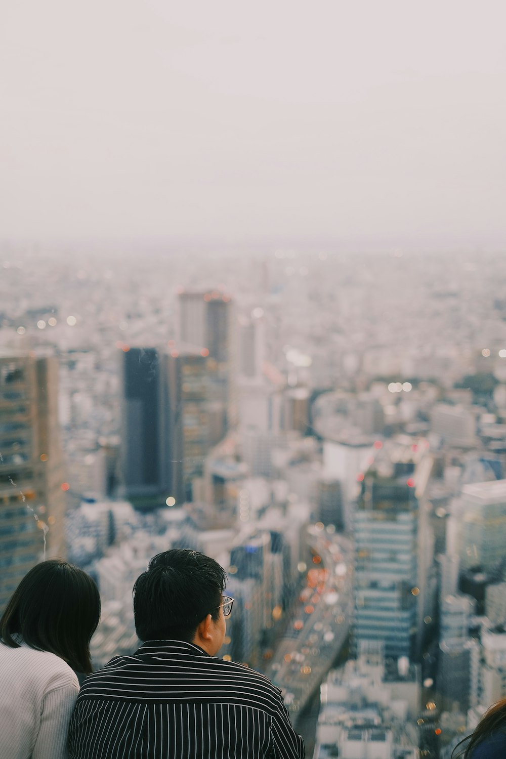 a couple of people standing on top of a tall building