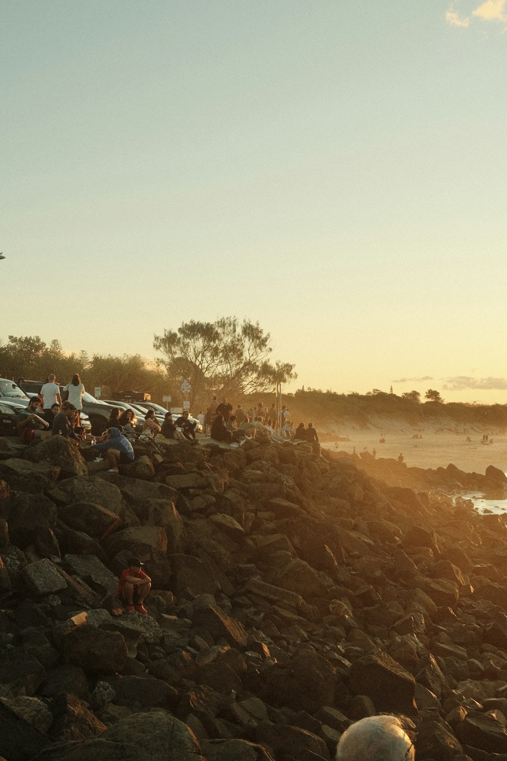 a group of people standing on top of a rocky beach