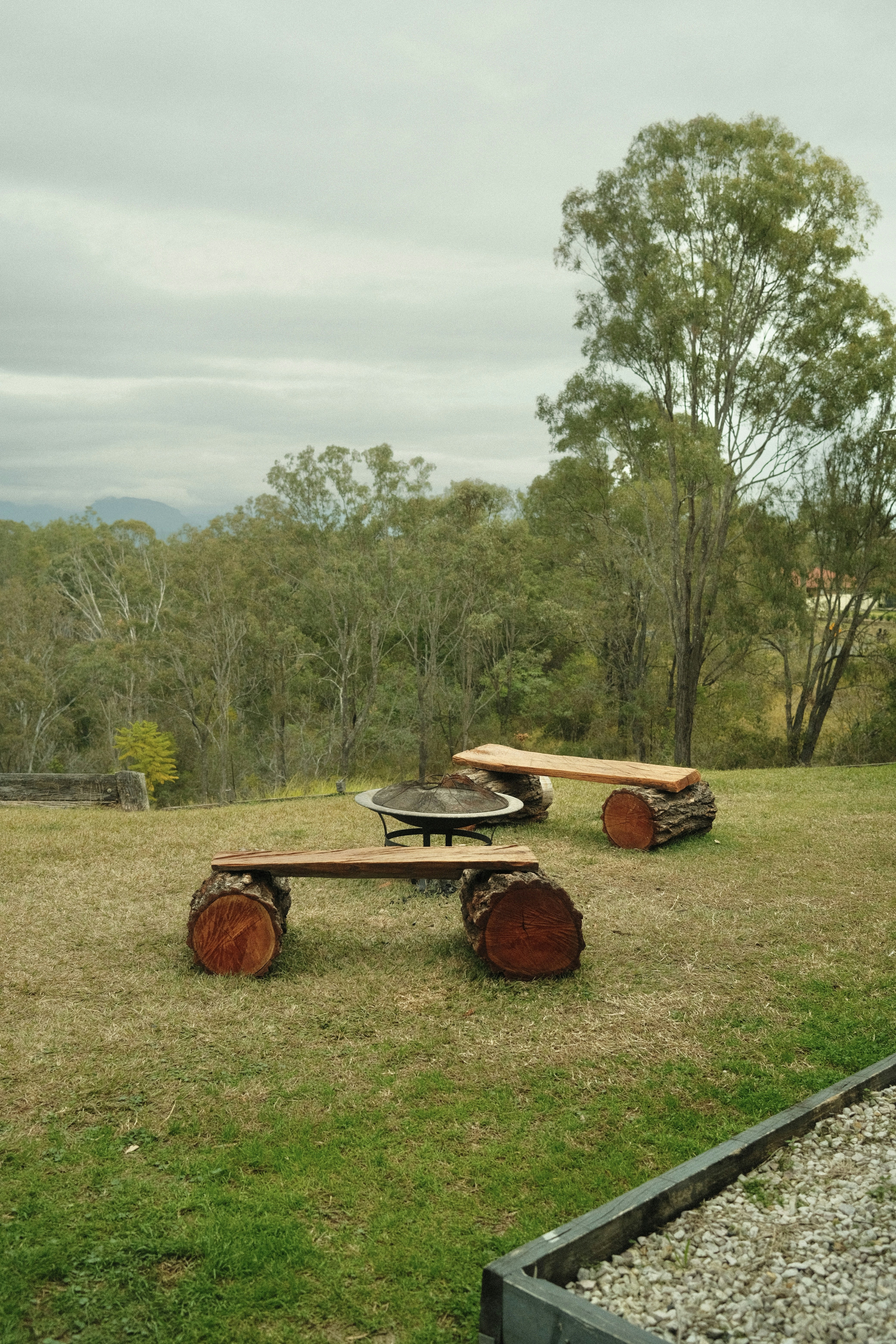 a couple of benches sitting on top of a lush green field