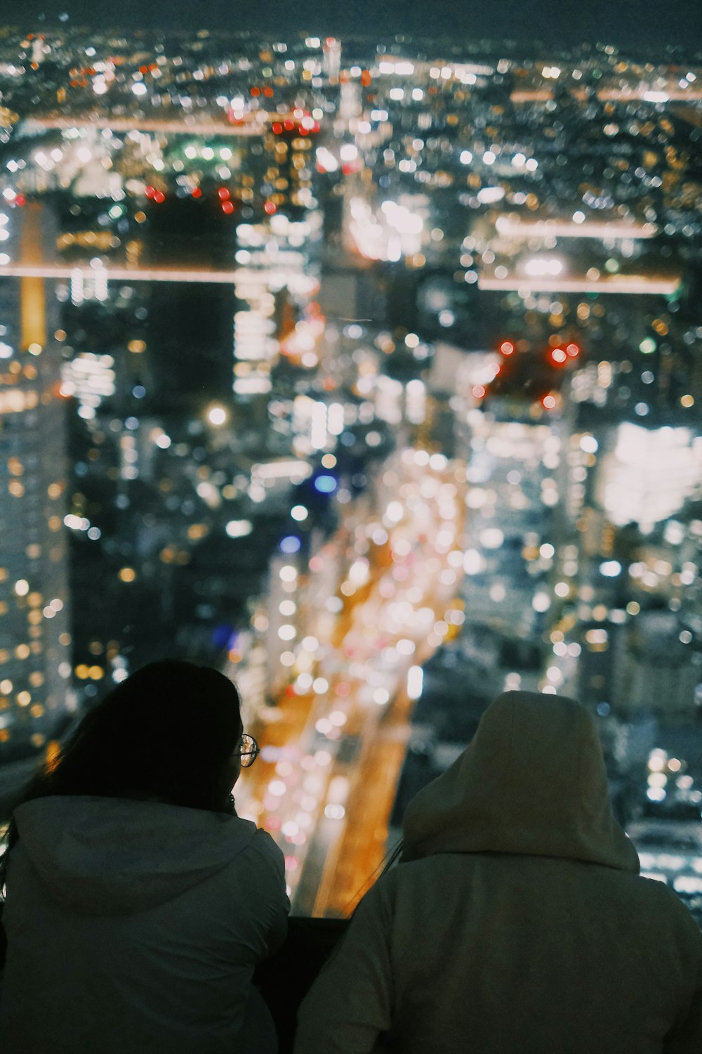 two people looking out over a city at night