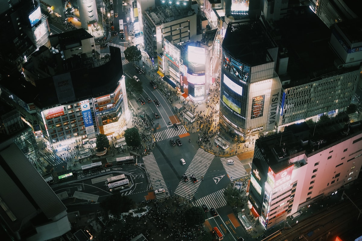 Shibuya crossing aerial view Tokyo at night thousands of people