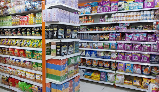 A vibrant display of assorted pet food bags and cans neatly arranged on wooden shelves.
