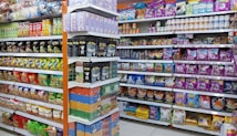 Shelves filled with a variety of packaged products, including snacks and pet food. The left side features chips and snacks in colorful bags, while the right side displays pet food bags and cans. The items are neatly organized, offering a vibrant and busy visual.