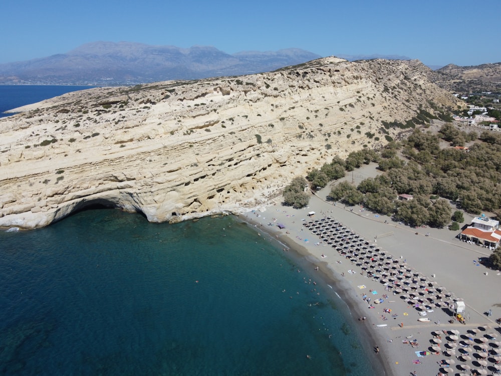 an aerial view of a beach with a cliff in the background