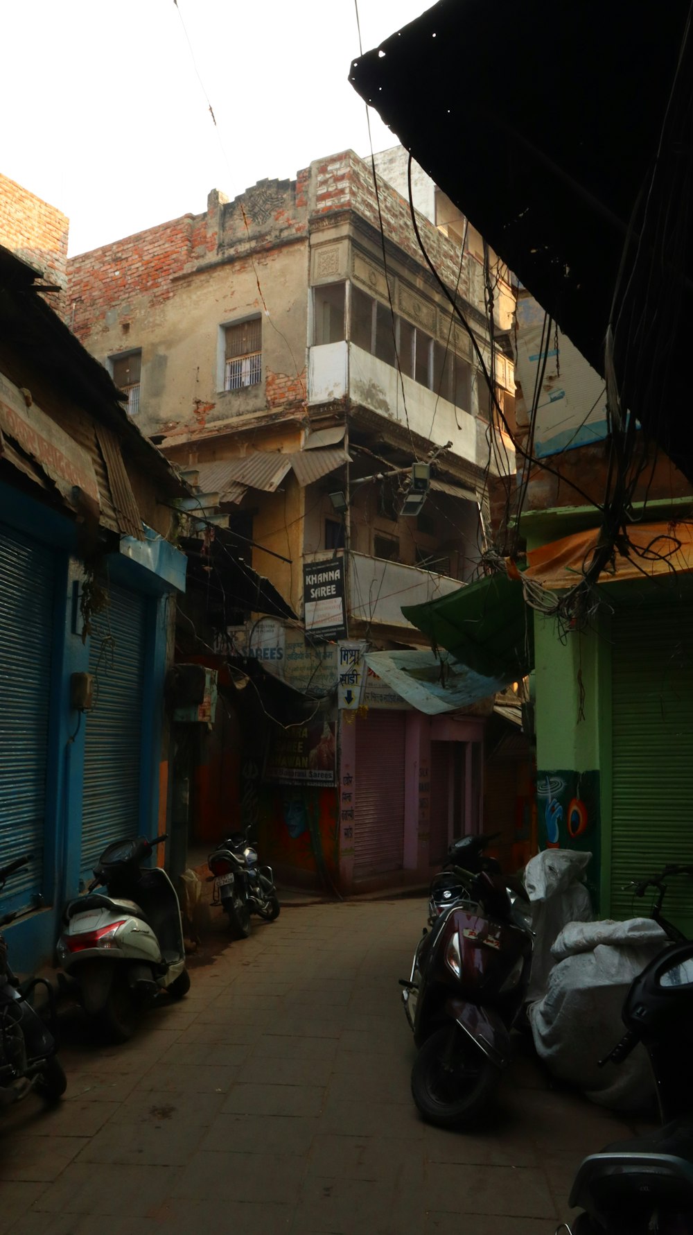 a narrow alley with a few motorcycles parked on the side of it