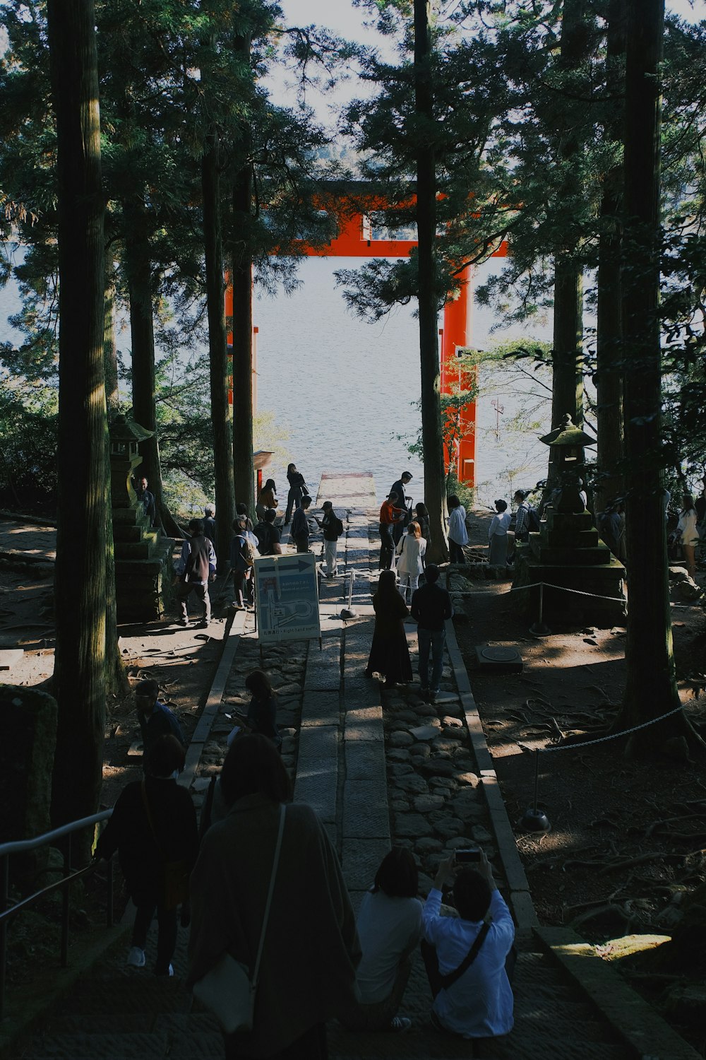 a group of people walking down a path next to trees