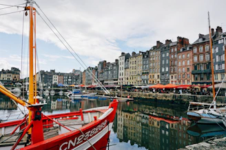 a red and white boat docked in a harbor