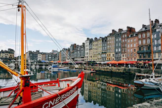 a red and white boat docked in a harbor