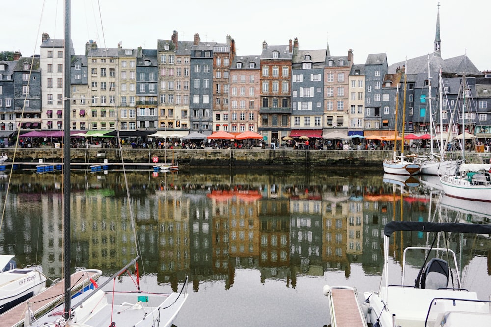 a harbor filled with lots of boats next to tall buildings