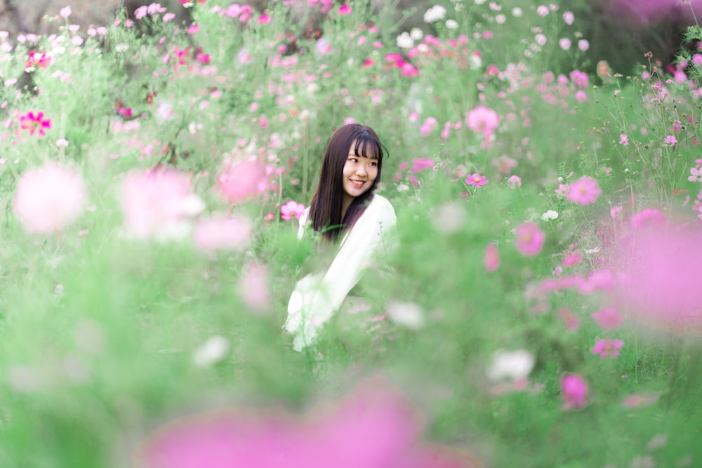 a woman sitting in a field of flowers