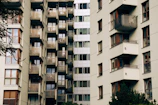 Apartment building facade with large windows and urban surroundings.