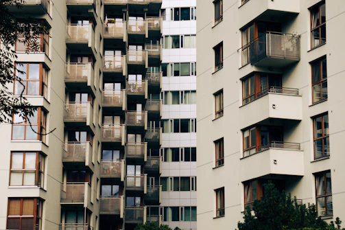 Apartment building facade with large windows and urban surroundings.