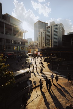 A candid shot of city dwellers crossing a busy intersection at sunset.