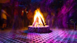 Evening campfire scene with family sharing stories, surrounded by neon and pastel decorations.