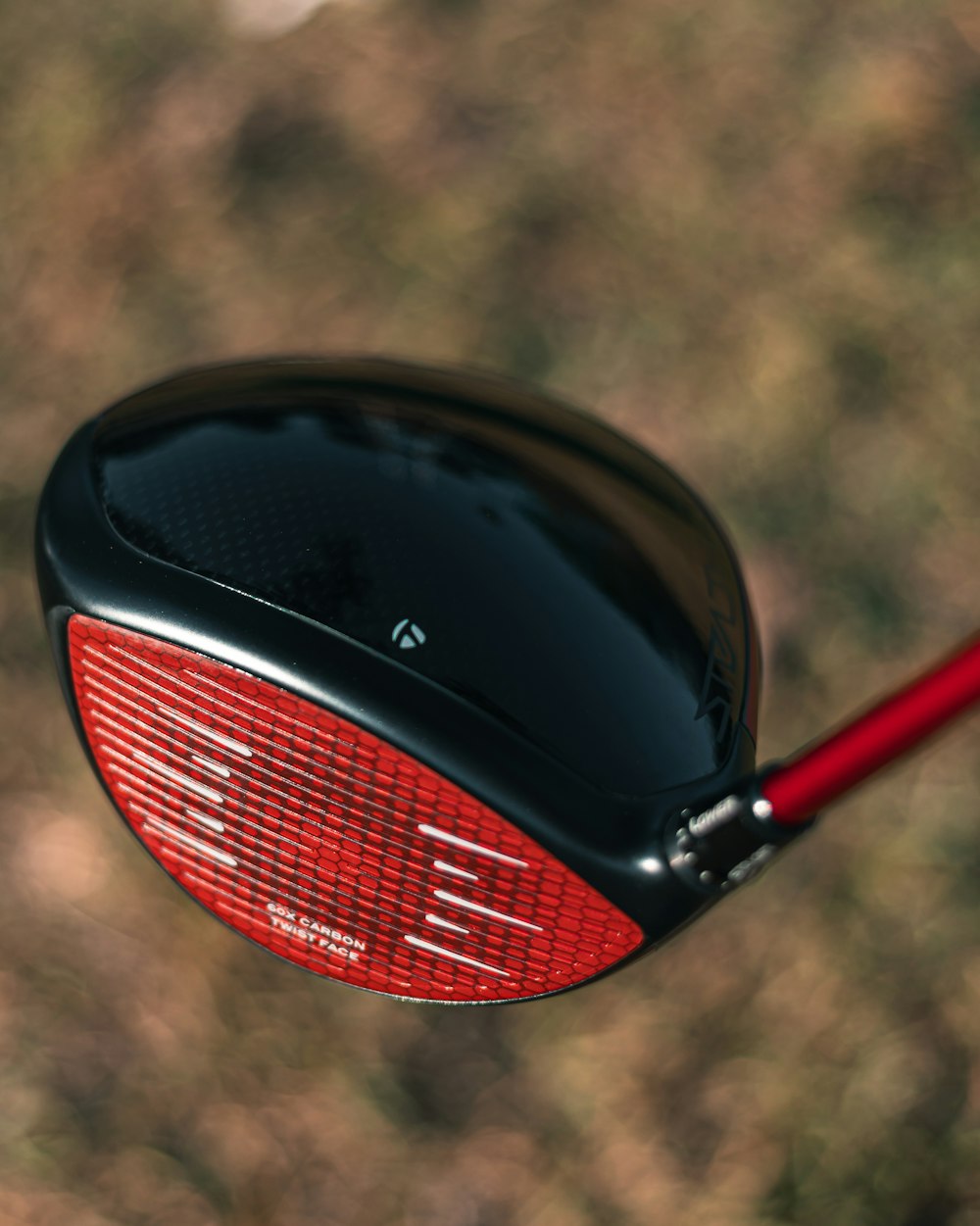 a close up of a red and black golf club