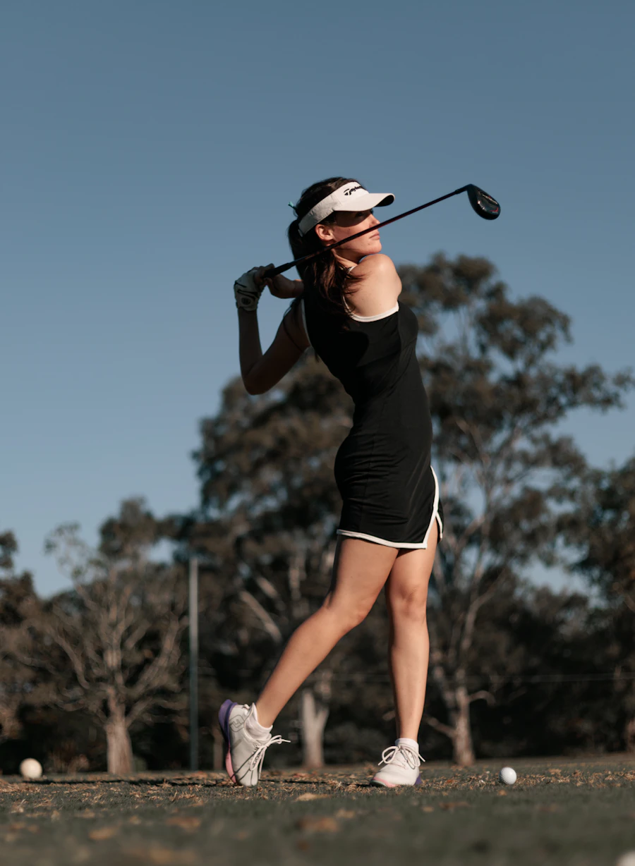 Golferin beim Abschlag in der Abenddämmerung