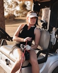 a woman is sitting on a golf cart