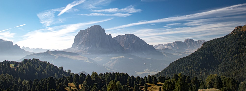 a view of a mountain range with trees and mountains in the background