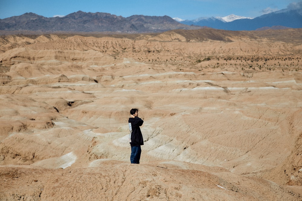 a person standing on top of a sandy hill