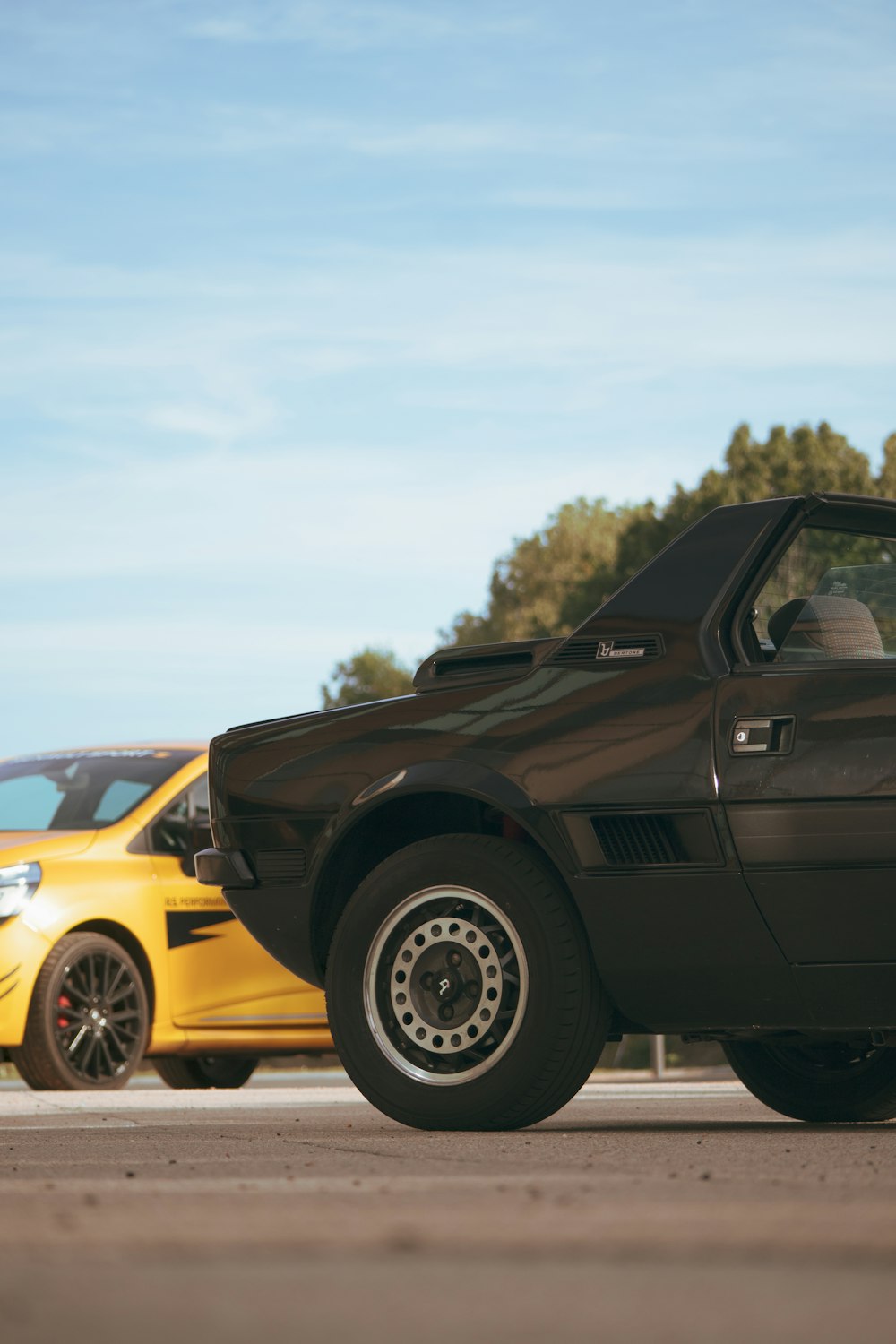 a black car parked next to a yellow car